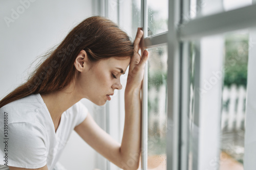 Depressive woman at home near the window. Pensive look of displeasure Free Download Depressive woman at home near the window. Pensive look of displeasure - GFXLoad