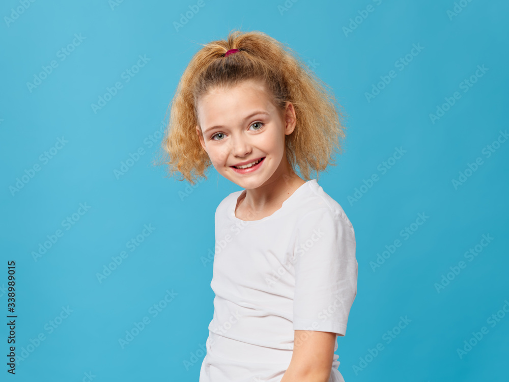 Cheerful girl curly hair white t-shirt smile blue background Cheerful girl curly hair white t-shirt smile blue background