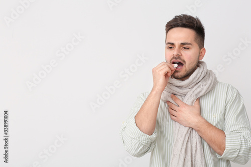 Ill young man taking pill o...