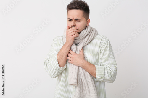 Coughing young man on light...