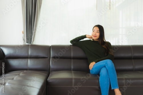 Beautiful portrait young asian woman sit relax on sofa