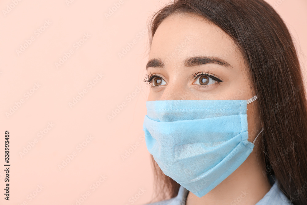 Young woman wearing medical mask against color background Young woman wearing medical mask against color background