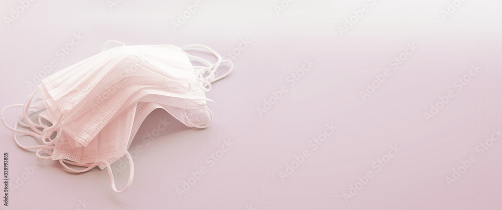 Set of white medical masks banner. Pink background. Face mask protection against pollution, virus, flu and coronavirus. Health care concept, copy space, free space for text Set of white medical masks banner. Pink background. Face mask protection against pollution, virus, flu and coronavirus. Health care concept, copy space, free space for text