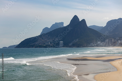 Waves coming in on Ipanema beach with the Two Brothers and Gavea mountain in the background during the COVID-19 Corona virus outbreak on a sunny midday in Rio de Janeiro, Brazil