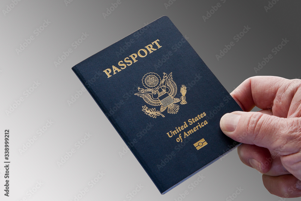 United States Passport, Close-Up With Hand, Grey Background United States Passport, Close-Up With Hand, Grey Background