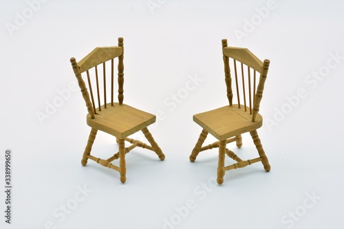 Dos sillas de madera enfrentadas   con fondo blanco