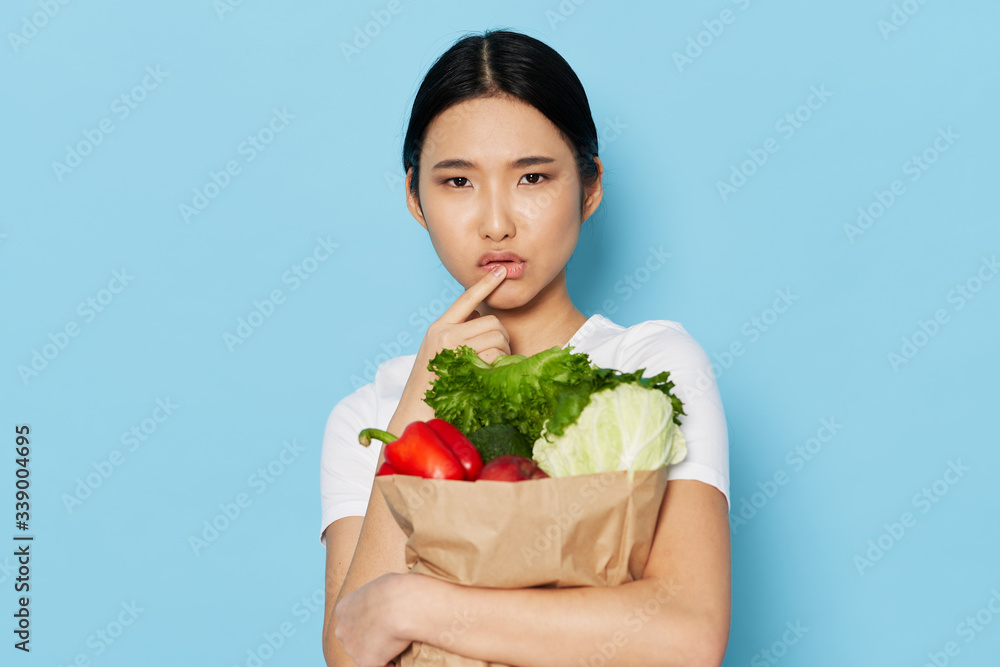 young woman holding a shopping bag full of groceries young woman holding a shopping bag full of groceries