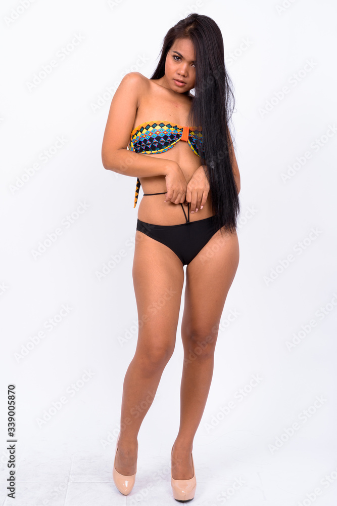 Young Asian woman wearing swimwear against white background Young Asian woman wearing swimwear against white background