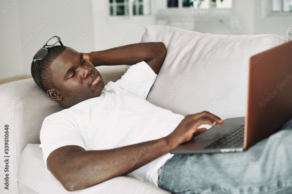 man relaxing on sofa with laptop man relaxing on sofa with laptop