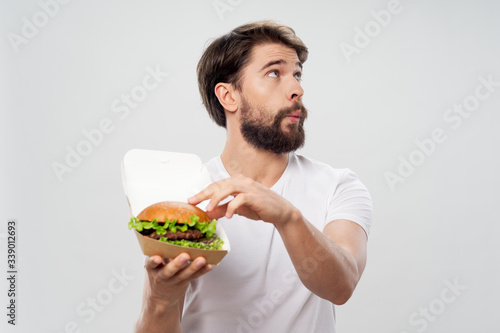 A man with a hamburger in his hands fast food diet eating meal snack