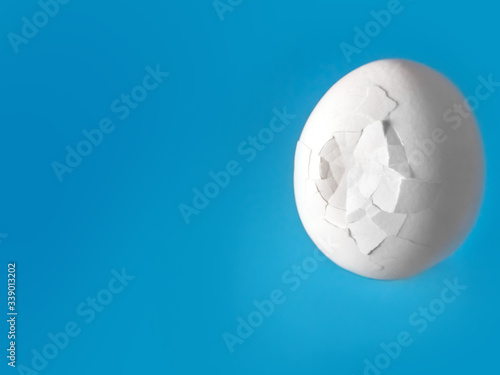 white broken egg with cracks on a blue background © Lema-lisa
