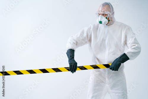 Healthcare worker cordoning off area with barrier tape during an outbreak of virus photo