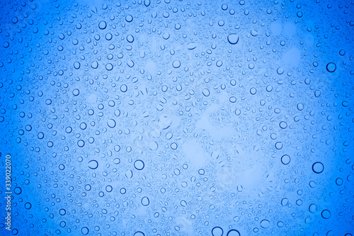 Rain droplets on blue glass background, Water drops on blue glass.