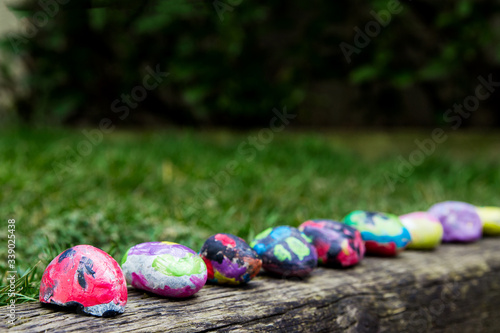 Rocks painted by a child with bright colors; painted rocks arranged in a row