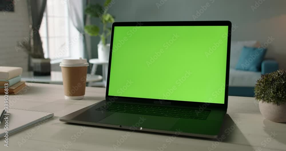 The table of distant worker at home. Modern laptop computer with chroma key green screen. Remote work, distance learning, technology concept close up 4k video template The table of distant worker at home. Modern laptop computer with chroma key green screen. Remote work, distance learning, technology concept close up 4k video template