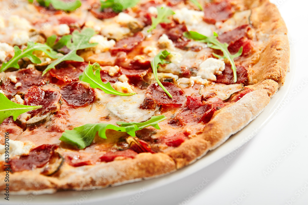 Pepperoni pizza slices with arugula on plate