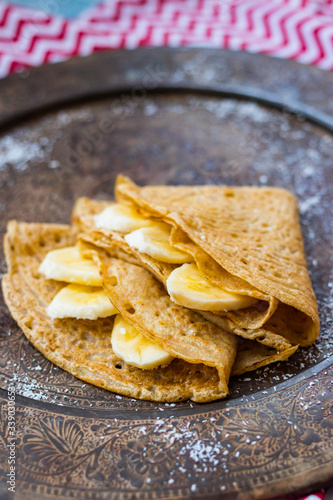Folded crepes or pancakes with banana fruits. Vegan sweet dessert food.