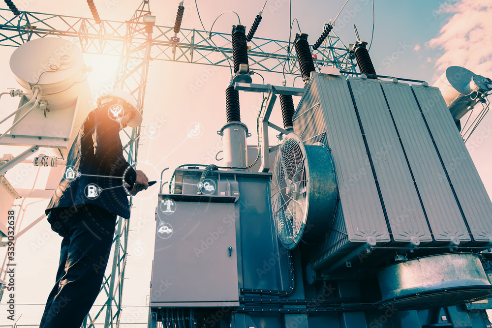 Ταπετσαρία Businessman wearing a black suit, standing looking at a large power transformer