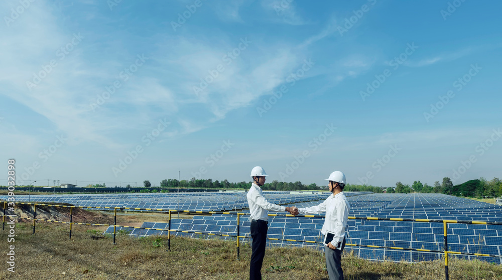 Businessman shaking hands at solar energy plant, Alternative energy to conserve the world's energy, Photovoltaic module idea for clean energy production Businessman shaking hands at solar energy plant, Alternative energy to conserve the world's energy, Photovoltaic module idea for clean energy production