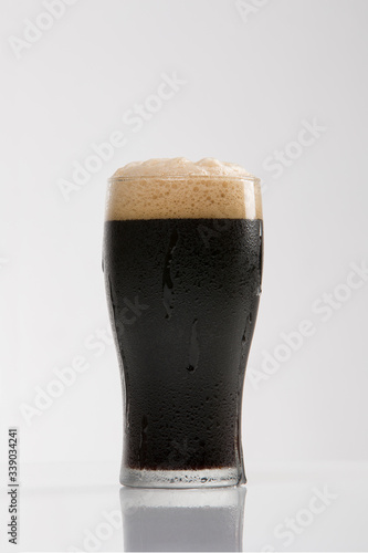 Dark Brown Thick Stout Beer in Frosted Glass Photographed in Studio on White Background