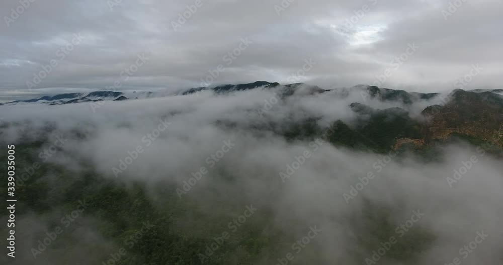 Green Mountain Range Surrounded by Clouds by a Muddy River in Grand Chaco Ecosystem Slow Aerial Travelling Green Mountain Range Surrounded by Clouds by a Muddy River in Grand Chaco Ecosystem Slow Aerial Travelling