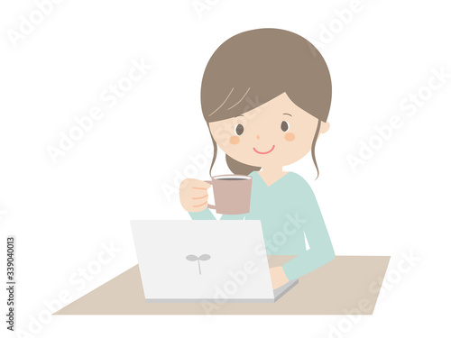 Woman drinking coffee while looking at the computer.