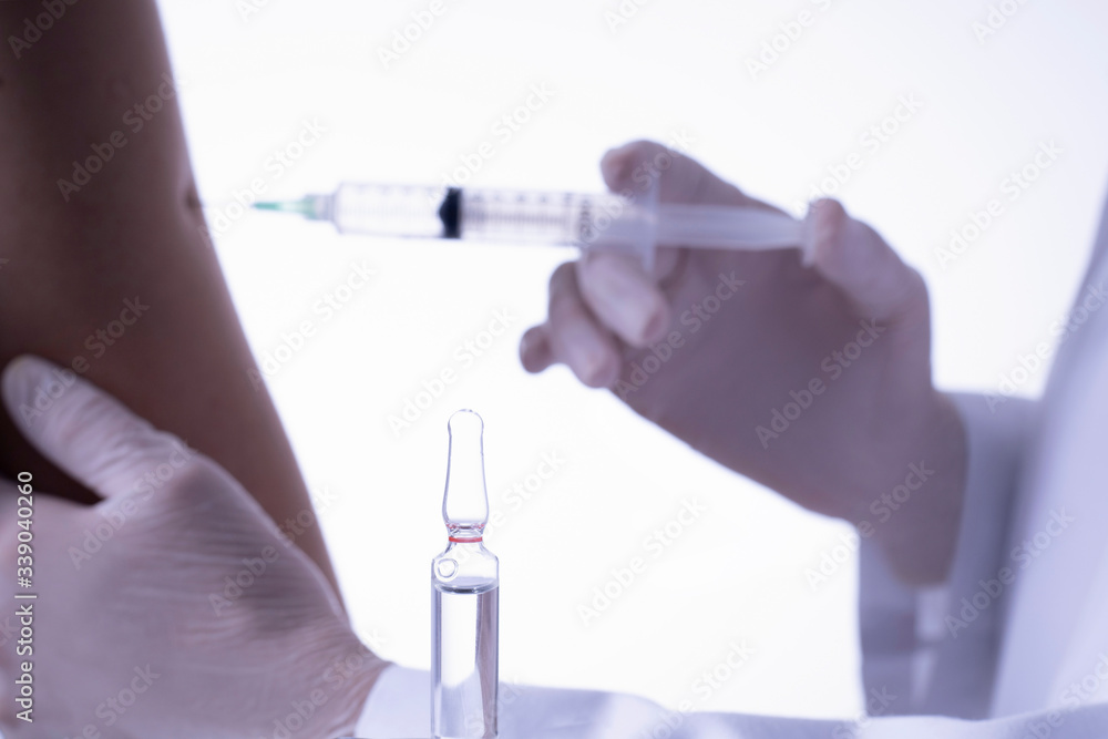 Fototapeta premium vaccination of person with ampule in foreground health concept