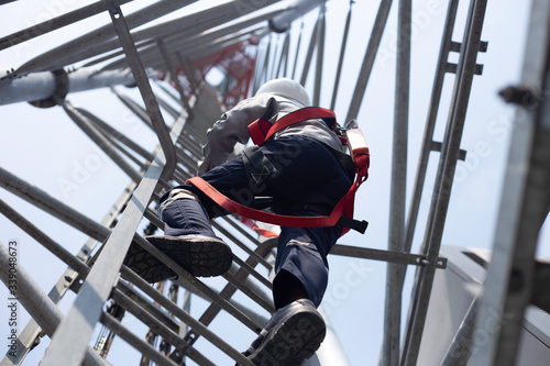 Engineer wear safety equipment climb high telecom tower for maintenance 5G network working  photo