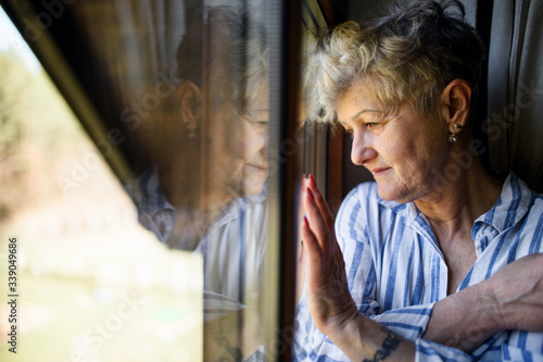 Sad senior woman standing indoors at home, corona virus and quarantine concept. photo