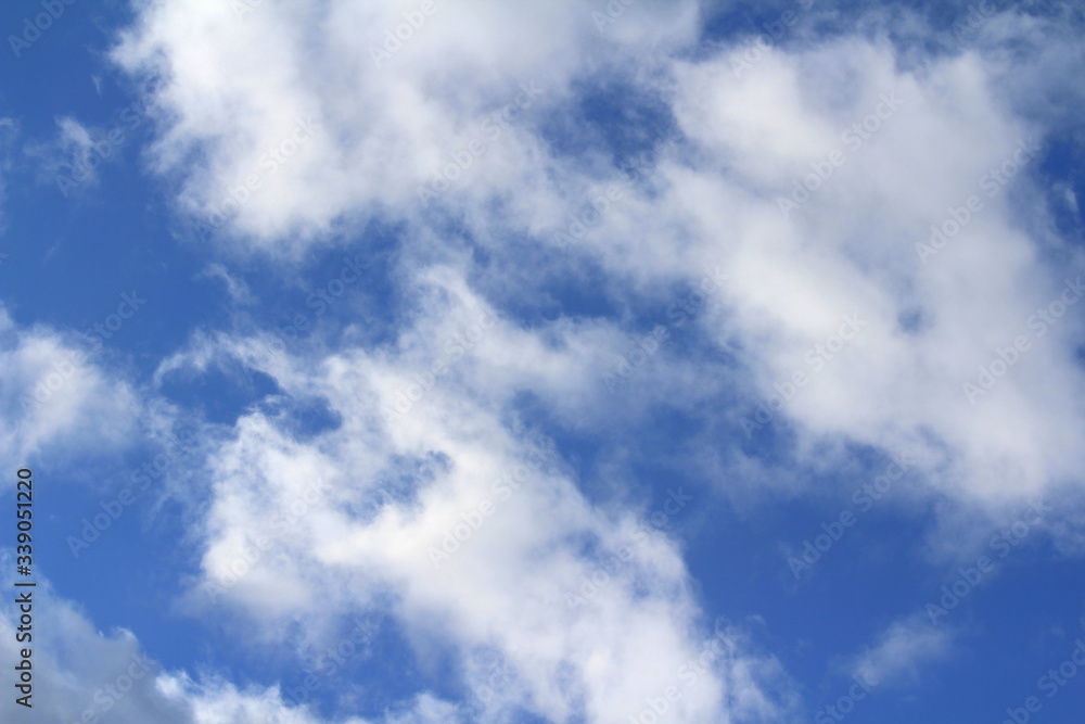 Clouds in the blue sky at sunset or dawn backlit by the sun. Place for text and design. Clouds in the blue sky at sunset or dawn backlit by the sun. Place for text and design.