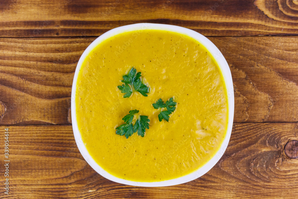Pumpkin soup on a wooden table. Top view Pumpkin soup on a wooden table. Top view