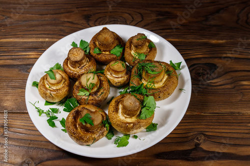 Baked mushrooms in plate on wooden table