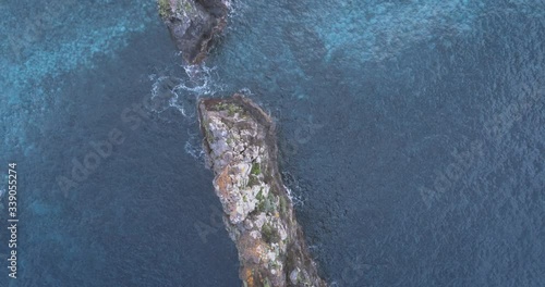 Aerial view over rock needle in Atlantic Ocean, Madeira island. Ilhéus da Ribeira da Janela. Navigating the sea. Drone view of ocean and rocks.