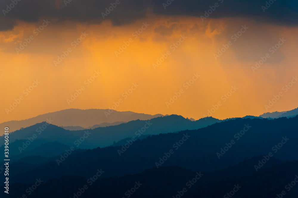 Silhouettes of the mountain hills and forest at sunset.