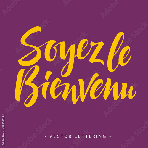 Bright yellow French Soyez le bienvenu inscription on purple background photo
