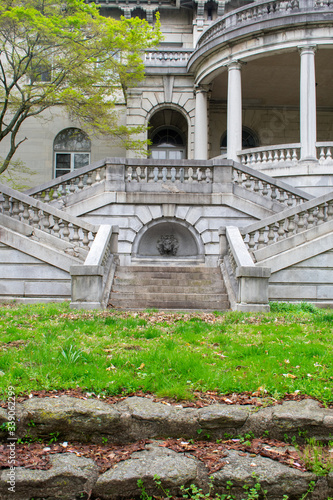 Detailed Stone Steps With a Turned Off Fountain Leading Up to an Abanoned Estate From a Grass Courtyard photo