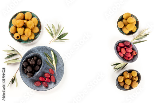 Olives, shot from above on a white background with copy space. A variety of green, black and brown olives