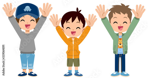 バンザイして喜ぶ小学生の男子の全身
