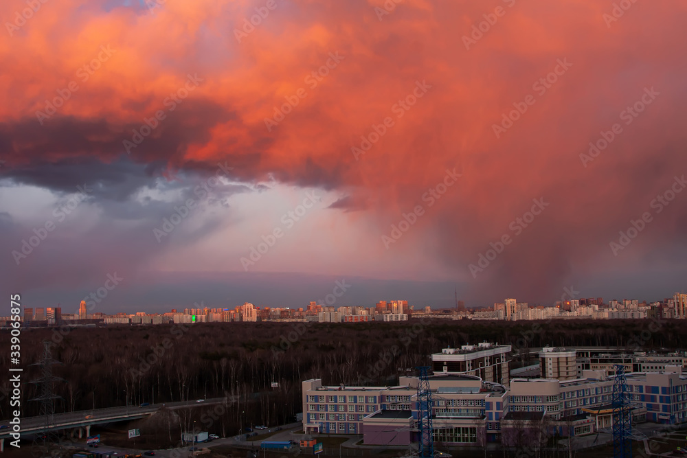Sunset view with rain clouds, forest and city in the distance Sunset view with rain clouds, forest and city in the distance