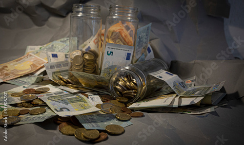 Euro coins and banknotes in a jar.
