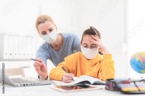Child home studying education  homeschooling  with private tutor   mother with protective mask in the time of viruses  flu and seasonal pandemic  healthy approach in social contact.