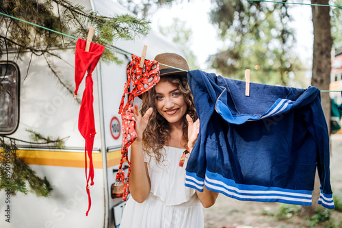 Young woman on camping holiday, hanging clothes on washing line. photo