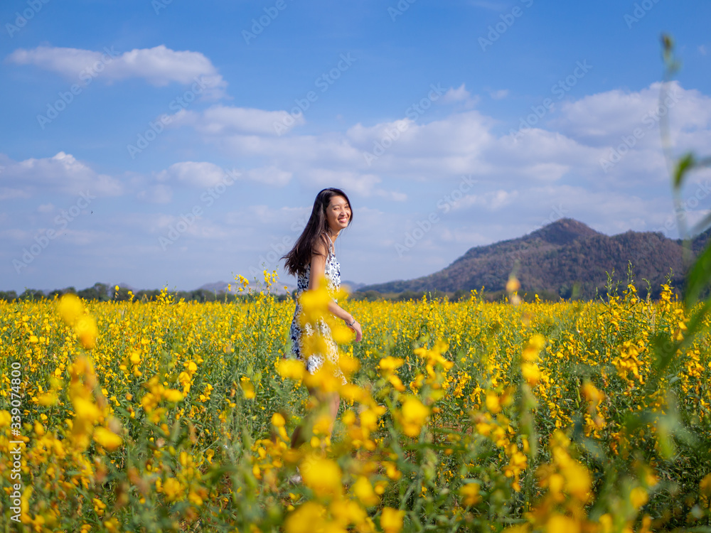Young happy girl walking on the flower field and enjoying fresh air. Young happy girl walking on the flower field and enjoying fresh air.