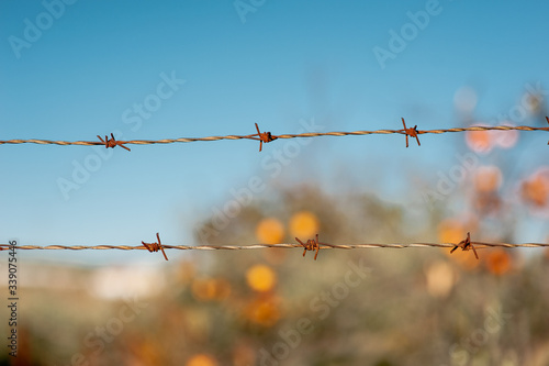 oxidized barbed wire with orange and blue blurred background