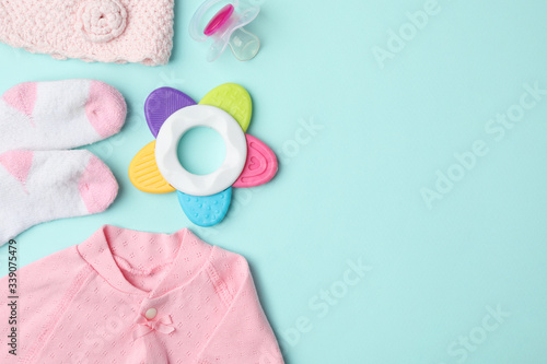 Flat lay composition with child's clothes and accessories on light blue background, space for text