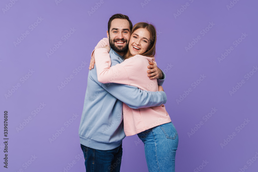 Positive loving couple posing over purple background. Positive loving couple posing over purple background.