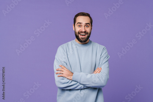 Emotional happy young man isolated over purple wall
