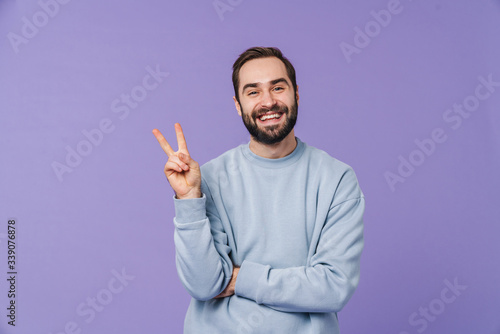 Positive happy young man showing peace gesture.
