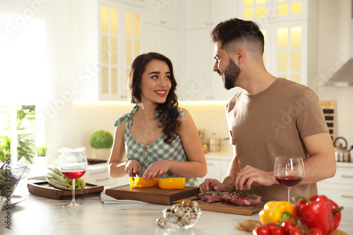 Lovely young couple cooking together in kitchen