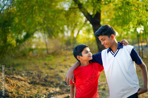 two little indian brother walking on road